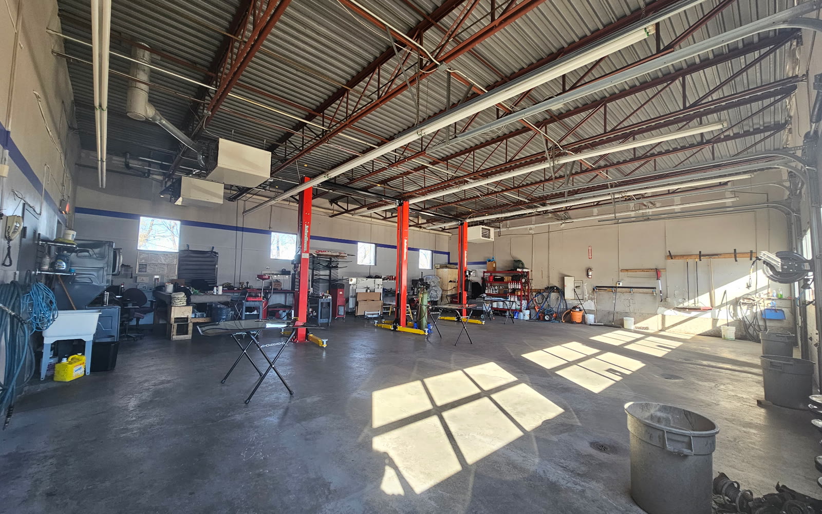 JB Auto repair bay with red lifts and shop equipment in Orléans